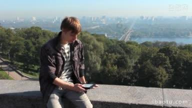 年轻男子在背景上阅读电子书，美丽的首都景色